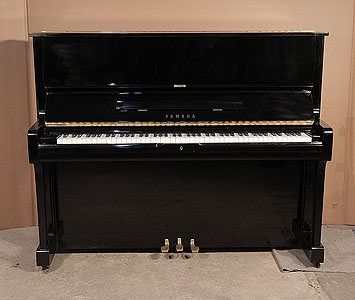  A 1986, Yamaha U1A upright piano with a black case and polyester finish. Piano has an eighty-eight note keyboard and three pedals.