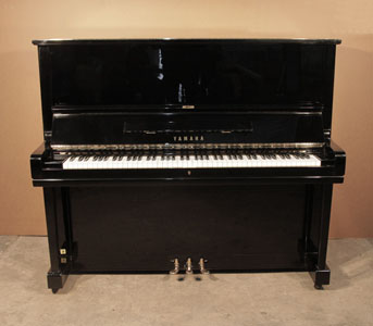  A  1969, Yamaha U3 upright piano with a black case and polyester finish. Piano has an eighty-eight note keyboard and three pedals.