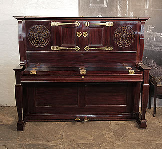 An 1897, Arts and Crafts style, Bechstein upright piano with a rosewood case, fretwork panels and ornate brass hinges in a stylised floral design. Unique design by Walter Cave. 