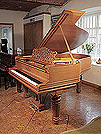 A 1900 Steinway Model A grand piano with a walnut case, filigree music desk and fluted, barrel legs with gadrooning detail.
