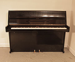 An Ibach upright piano with a poished, black case and brass fittings.