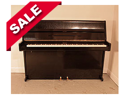 Piano for sale.  Ibach upright piano with a poished, black case and brass fittings. Piano has an eighty-eight note keyboard and two pedals. 