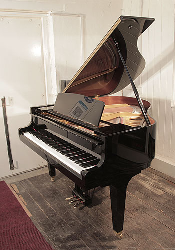 Piano for sale. A 2009, Kawai GM-10K baby grand piano for sale with a black case and square, tapered legs. Piano has an eighty-eight note keyboard and a three-pedal lyre.