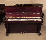 Piano for sale. Samick SU-121 upright piano with a mahogany case and brass fittings. Piano has an eighty-eight note keyboard and three pedals.