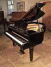 Piano for sale. Reconditioned, 1973, Yamaha G1 baby grand piano for sale with a black case and square, tapered legs. Piano has an eighty-eight note keyboard and a two-pedal lyre.