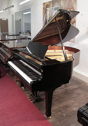 Reconditioned, 1990, Yamaha G1 baby grand piano for sale with a black case and spade legs. Piano has an eighty-eight note keyboard and a three-pedal lyre. 