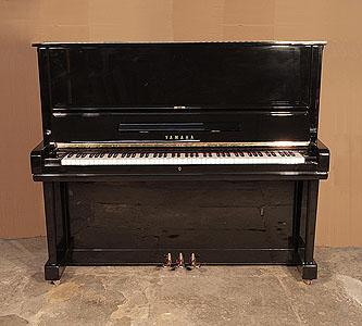 A 1969, Yamaha U3 upright piano for sale with a black case and brass fittings. Piano has an eighty-eight note keyboard and three pedals.  