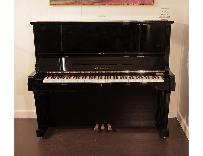 Reconditioned, 1987, Yamaha UX-3 upright piano for sale with a black case and brass fittings. Piano has an eighty-eight note keyboard and three pedals. 