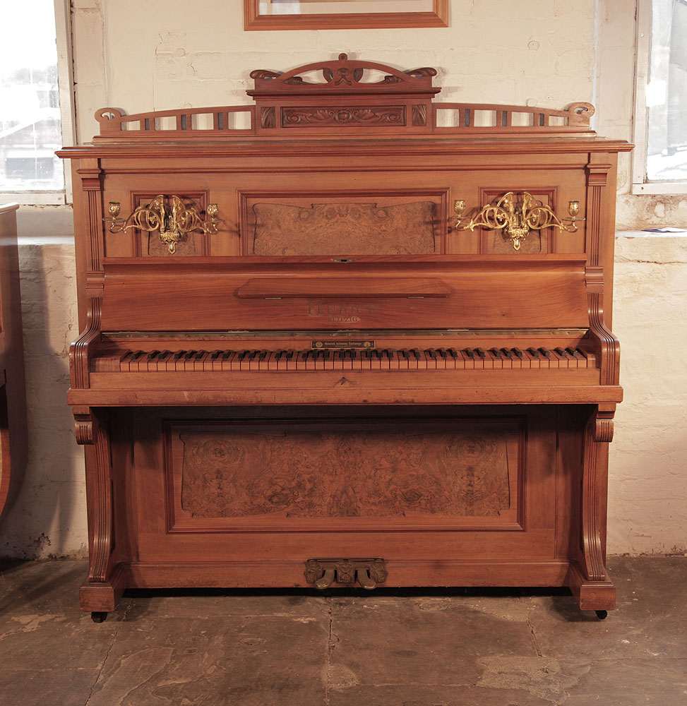 Feurich upright piano with a walnut case with burr walnut panels and an