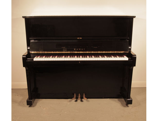 Reconditioned, 1973, Kawai BL-51 upright piano with a black case and brass fittings. Piano has an eighty-eight note keyboard and three pedals.  