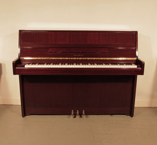A 1988, Kawai CE10N upright piano for sale with a mahogany case and brass fittings