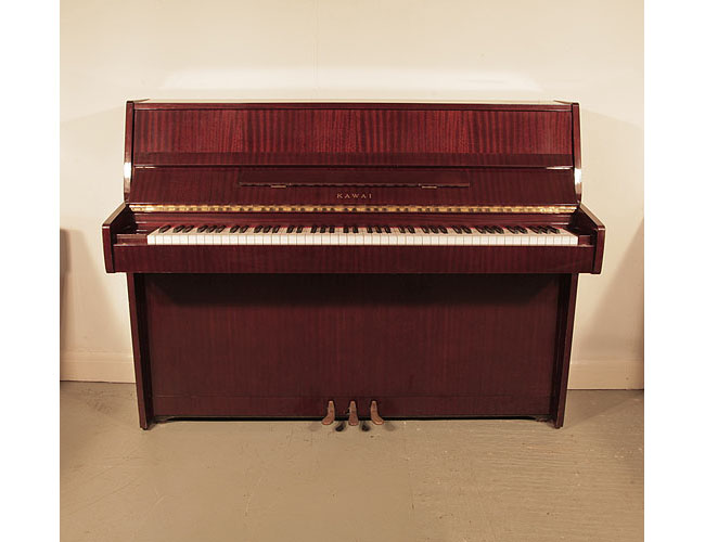 A 1982, Kawai CE-7N upright piano for sale with a mahogany case and brass fittings. Piano has an eighty-eight note keyboard and three pedals. 