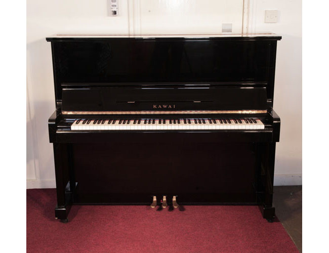 Reconditioned, 1982, Kawai KS-2F upright piano with a black case and polyester finish. Piano has an eighty-eight note keyboard and three pedals.   