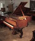 Restored, 1877, Steinway & Sons Style 1 grand piano for sale with a Rococo style, rosewood case, filigree music desk and ornately carved, reverse scroll legs. The piano cheek with dual linear case moulding features a carved, Classical meander and acanthus in high relief. The three-pedal piano lyre features a carved shell motif. The music desk is an openwork arabesque design and a central lyre motif. Piano has an eighty-five note keyboard.  