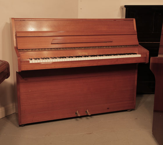 A Sterling upright piano for sale with a polished, teak case and brass fittings  