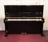 Piano for sale. Reconditioned, 1974, Yamaha U1 upright piano with a black case and polyester finish. Piano has an eighty-eight note keyboard and three pedals. 