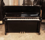 Piano for sale. A 1973, Yamaha U1 upright piano with a black case and polyester finish. Piano has an eighty-eight note keyboard and three pedals.