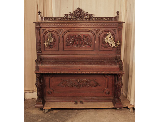 Neoclassical style, Francke upright piano for sale with an ornately carved, oak case and griffin legs. Cabinet features carved angels, lions heads, acanthus and openwork arcading