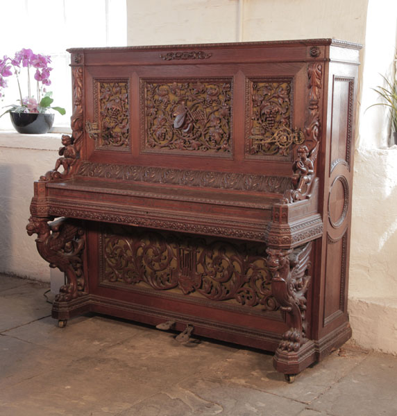 Biese Hof upright piano for sale with an ornately carved, oak case and griffin legs Piano has an eighty-five keyboard and two pedals.