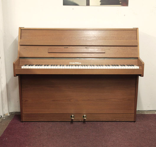 British-Made, Chappell upright piano with a walnut case. A small upright piano ideal for compact living spaces. Piano has an eighty-eight note keyboard and two pedals. 