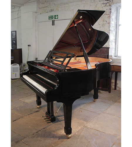 Pre-owned, Feurich model 178 Professional II grand piano with a black case and brass fittings. Piano has an eighty-eight note keyboard and a three-pedal lyre. 