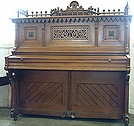 An art cased Seiler XB upright piano in french polished sycamore. In good working order. Rare gothic style.