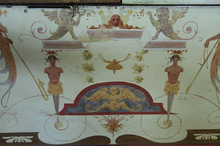 Detail of hand-painted decoration on the Pleyel piano cabinet. Here two winged lions sit on pedestals, beneath are two figurehead male busts, a central pediment with carvings of an angeland arabesques