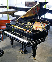 A restored, Berdux grand piano with a polished, black case and turned legs. Music desk features an art nouveau cut-out design with sinuous tendrils and the Berdux name.