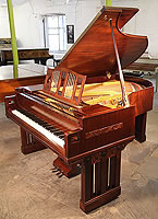 A 1916, Arts and Crafts Ibach grand piano with a polished, mahogany case.
