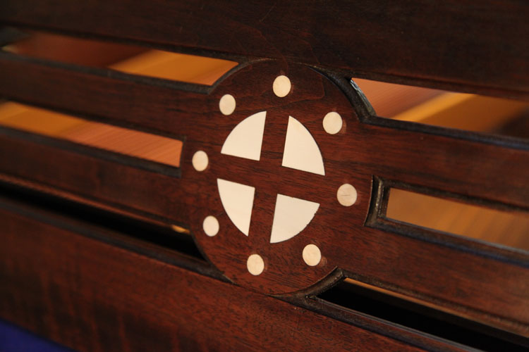 In the centre of the music desk is an inlaid circle with central cross. Viewed as a Norse symbol, this suggests the sun wheel, one of the oldest spiritual symbols of the Germanic people. The central cross seperates the circle into four pieces, just like the seasons in a year. It is representative of life, fertility and peace.