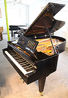 A 1935, Bosendorfer grand piano for sale with a black case, slatted music desk and square, tapered legs