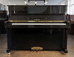 A Brand New Besbrode 122 upright piano with a black case. Piano has an eighty-eight note keyboard and three pedals. 