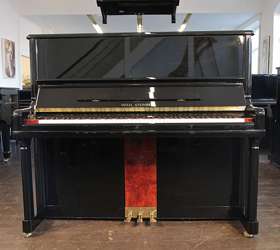 A Brand New Steinberg Model AT-32 upright piano with a black case, walnut panel and brass fittings