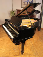 A restored, 1914, Steinway Model O grand piano with a black case and spade legs. 