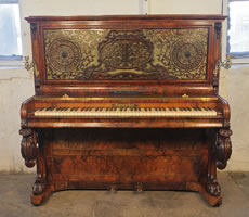 A Burling & Burling upright piano with a burr walnut case. Cabinet features an ornate fretwork front panel, moveable brass candlesticks and carved, cabriole legs