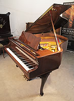 A Petrof grand piano with a walnut case and cabriole legs