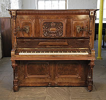 An 1898, Steingraeber upright piano with a walnut case, Cabinet features a carved, Neoclassical style filgree panel and ornate brass candlesticks