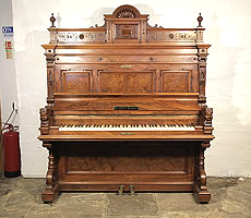 Antique, Ehret upright piano with a walnut case. Cabinet features piano cheeks with carved female heads and carved pediment with orbs