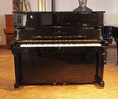A 1985, Steinway Model V upright piano with a black case and brass fittings