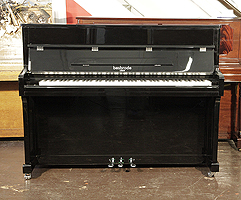 A brand new, Besbrode SU113 upright piano with a black case and chrome fittings. Piano features a slow fall mechanism