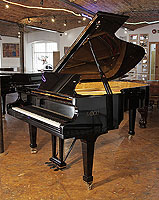 A 2006, Fazioli F212 grand piano with a black case and spade legs. Piano features a slow fall mechanism
