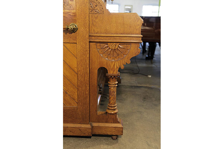 Ibach carved piano cheek featuring folk art motifs including a sun design in a half hex and stylised bird in flight. Piano legs are turned in a stylised Corinthian design with carved spiraling detail