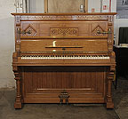 Piano for sale. An 1895, English Gothic style, Ibach upright piano with a carved, oak case and inlaid panels featuring traditional folk art elements.