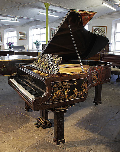 An 1899, Chinese Chippendale style, Schiedmayer grand piano for sale with a flame mahogany case and Malborough legs with applied fret carvings. Cabinet features Chinese scenes in embossed Japanning with gilt ornament.