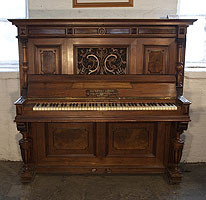 An 1898, Steingraeber upright piano with a Neoclassical style, carved walnut case and cup and cover legs. Cabinet features a front panel carved with acanthus and dragon heads in high relief.