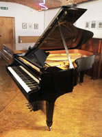 A 1974, Steinway Model B grand piano with a black case and spade legs.