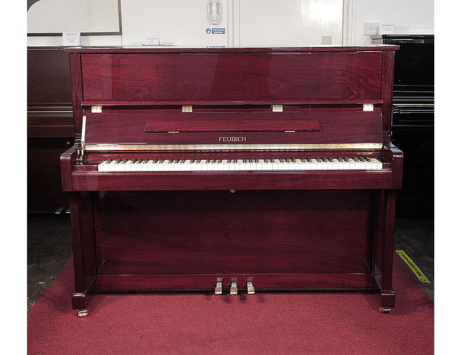 Brand new, Feurich Model 122 upright piano with a mahogany case and brass fittings. Piano features a slow fall mechanism. Piano has an eighty-eight note keyboard and three pedals. 