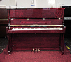 A brand new, Feurich Model 122 upright piano with a mahogany case and brass fittings