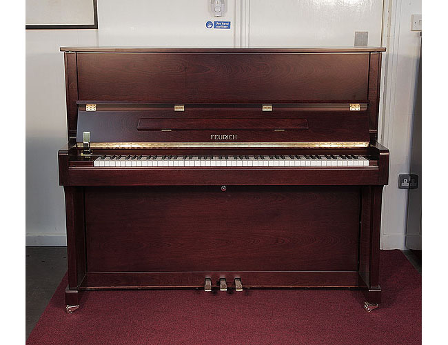  Brand new, Feurich Model 122 upright piano with a satin, walnut case and brass fittings. Piano has an eighty-eight note keyboard and three pedals.  