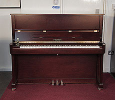 A brand new, Feurich Model 122 upright piano with a satin, walnut case and brass fittings